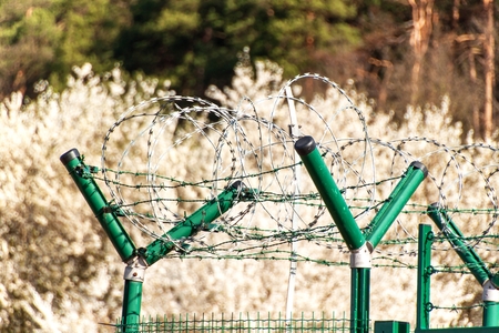 Fence with razor barbed wire. Guarded area. Military base. Razor wireの写真素材
