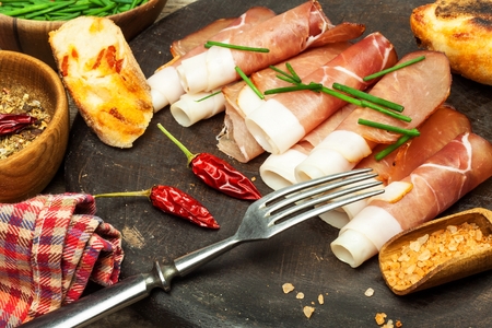 Thinly sliced ??German black forest ham with sliced ??ciabatta bread. Sliced ??and smoked ham with ham or prosciutto. Traditional German foodの写真素材