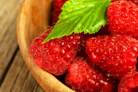 Fresh raspberries on a wooden table. Forest fruit. Healthy food. Sale of raspberries