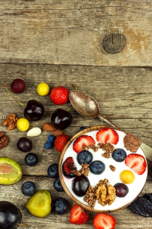Yogurt with summer fruit on a wooden table. Fruit refreshment. Snack for childrenの写真素材