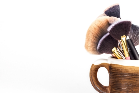 Makeup brushes in a ceramic mug on a white background. Cosmetic industry. Brush for beauty. Beautiful women. Detailed viewの写真素材