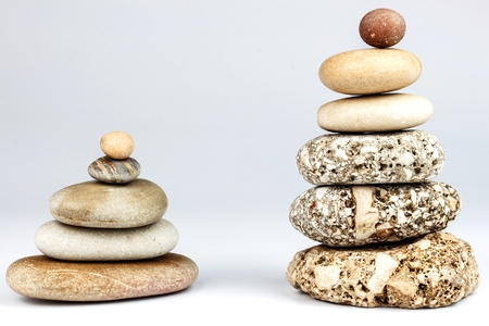 Pyramid of pebbles on a white background. Stones on the table. Wellness concept. Sea stonesの写真素材