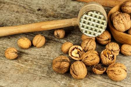 Walnut kernels and whole walnuts on a rustic old wooden table. Food photography. Autumn harvest. Peeling nutsの写真素材