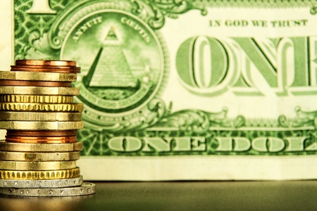 Euro coins on one dollar banknotes as background. Close-up of several euro coins. Concept of trading on the stock exchange. Euro exchange rateの写真素材