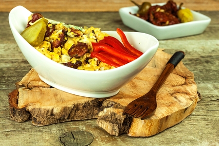 Mixed egg with sausage in a ceramic dish. Breakfast from eggs. Healthy food. Protein for breakfast