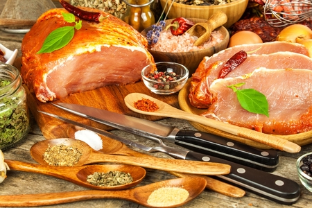 Pork chop on old wooden table. Raw meat and spices. Marinated pork meat on grill. Food preparation.の写真素材