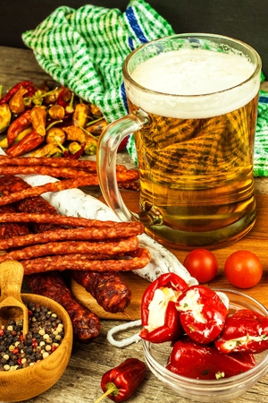 Beer and sausages on a wooden table. Sale of beer and sausage. Food for beer. Unhealthy food.の写真素材
