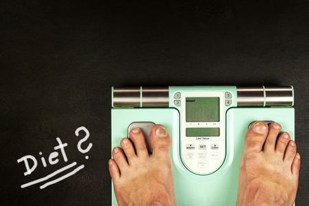 Obesity concept. Modern digital weight and legs. Weight control on diet.の写真素材