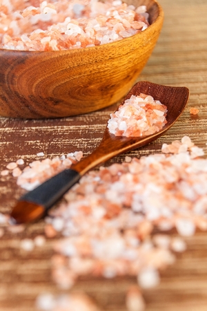 Himalayan pink salt on wooden background. Kitchen salt. Spices on grill.の写真素材