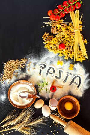 Home made traditional pasta. Flour grain egg paste on black background. Home cooking food.の写真素材