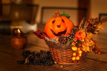 Halloween background decorated holidays festive concept. Jack o lantern pumpkin halloween decorations on wooden table. Burning candle, autumn evening on the terrace.の写真素材