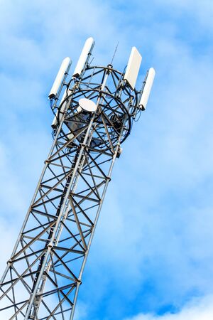 Telecommunication mast against blue sky. Autumn landscape with flagpole. Modern broadcast...
