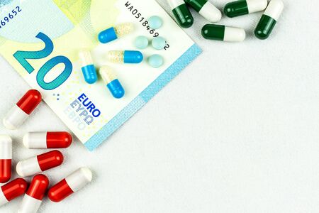 Financing of health care. Medicine, finance, health care and drug trafficking - medical pills or drugs and euro cash money on white background.の写真素材
