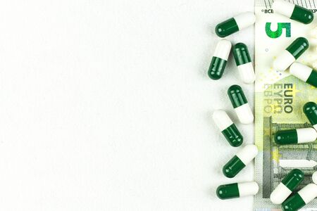 Financing of health care. Medicine, finance, health care and drug trafficking - medical pills or drugs and euro cash money on white background.の写真素材