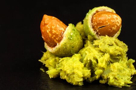 Wasabi Coated Peanuts on slate board. Japanese Wasabi Spice. Green wasabi peanuts on a black plate on a dark background.の写真素材
