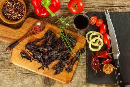 Dried meat on kitchen table. Domestic production of dried beef. Meat marinated in chilli. Diet food. Durable food. Proteins for athletes.の写真素材