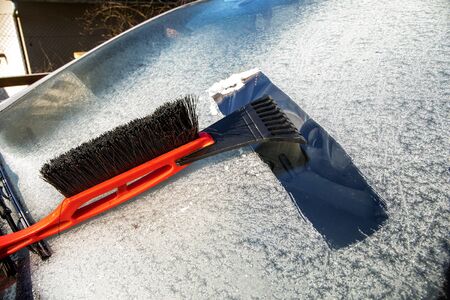 Frozen car windshield covered with ice and snow on a spring day. Frosty morning. Spring frost on the...