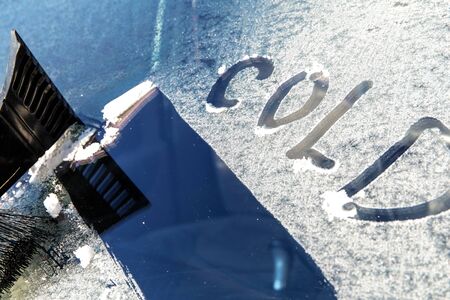 Frozen car windshield covered with ice and snow on a spring day. Frosty morning. Spring frost on the car. Ice scraping.の写真素材