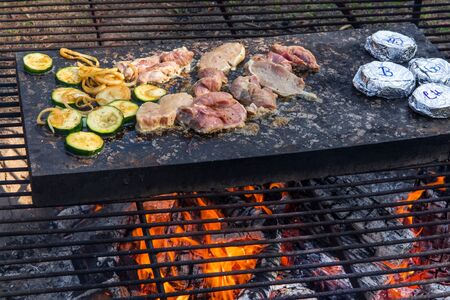 Barbecue on granite stone. Open fireplace for grill. Grilled turkey meat and vegetables. Granite...