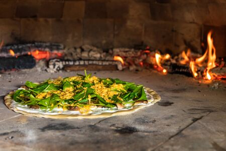 Preparing homemade spinach pizza with mushrooms. Vegetarian pizza. Home baking. Healthy food. Traditional Italian food.の写真素材