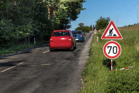 Roadworks signs on a Country Road and Blue Sky. Summer morning on a country road in the Czech Republic. Road repair. Road sign.の写真素材