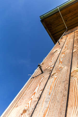 Log wall of modern wooden house under construction. Detail of lightning conductor. Ecological house. Storm protection.の写真素材