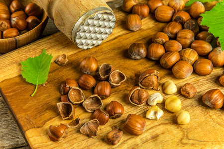 hazelnuts on wooden table, top view. Food background. Heap of many whole ripe brown hazel nuts....