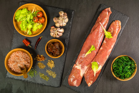 Pork tenderloin. Fresh raw meat prepared for cooking. Organic pork meat on chopping board ready for...
