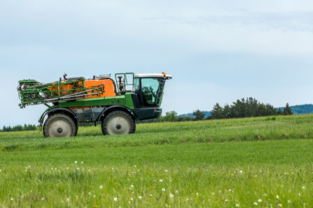 Tractor spray fertilize field with insecticide herbicide chemicals in agriculture field in Czech...