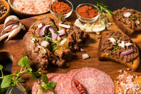 Traditional homemade French steak tartare of raw beef. Steak tartar with chopped onion and herbs on...