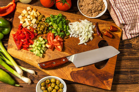 Tasty tuna salad with vegetables on wooden table. Vegetable salad with tuna. Preparing a healthy vegetable salad with fish. Diet food for athletes.の写真素材