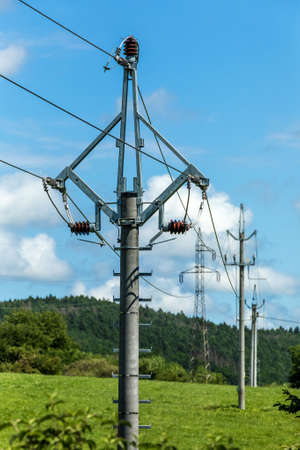Green pasture, blue sky and power lines in the Czech countryside. Electricity distribution. Ecological energy.の写真素材