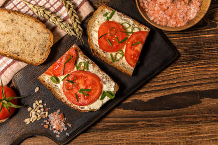 Fresh homemade rustic wholegrain bread with butter and tomatoes. Homemade bread.Traditional meal. Country food.の写真素材
