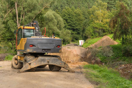 Repair of a road bridge in the Czech Republic near the village of Rikonin. Excavator on an empty...