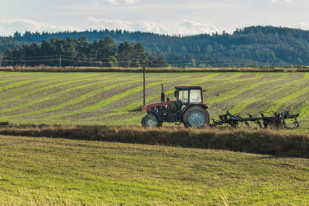Plowing a field. Tractor with a plow. Farming in the countryside. Autumn work on the farm in Czech Republic.の写真素材