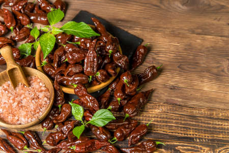 Chili pepper on wooden background.Extra hot chili. Naga Bhut Jolokia Chocolate. Exotic spices. Hot ingredients for food.の写真素材