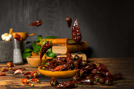 Chili pepper on wooden background.Extra hot chili. Naga Bhut Jolokia Chocolate. Exotic spices. Hot ingredients for food.の写真素材