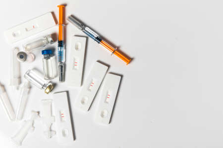 Positive SARS-CoV-2 Rapid Antigen Test and syringes. COVID-19 vaccine. Pandemic vaccination.の写真素材
