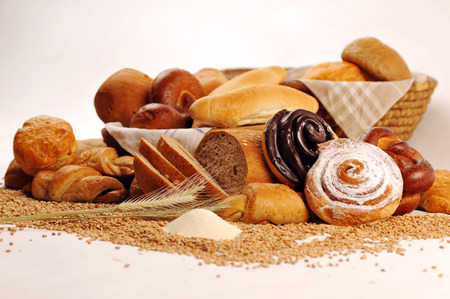 Composition with bread and rolls in wicker basket, combination of sweet pastries for bakery or...