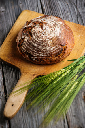 rye bread with grains on wooden breadboard, food background, freshly baked traditional breadの写真素材