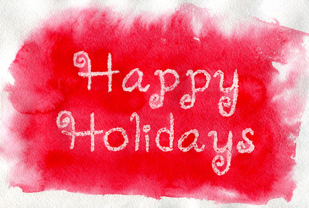Happy Holidays. White lettering made by wax crayons on the red watercolor background.の写真素材
