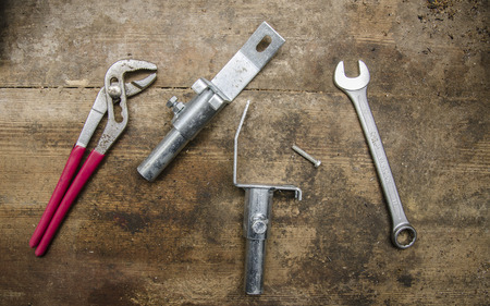 Tools and parts on old wooden tableの写真素材