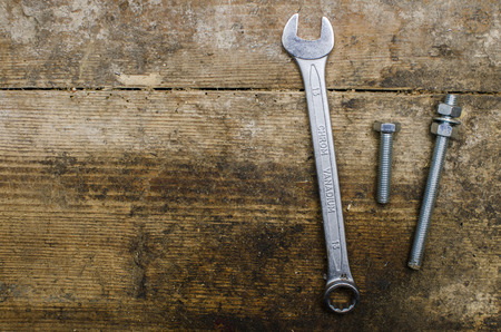 Wrench and screw on old wooden tableの写真素材
