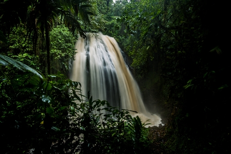 Beautiful big waterfall located inside of a green forest with stones in river at Baezaの写真素材