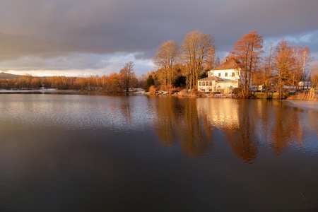 Beautiful winter landscape at the pond. Colorful sunset with blurred, out of focus reflection in the water.の写真素材