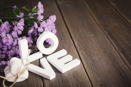 Cute love words, hearts and flowers on rustic wooden table for copy space の写真素材