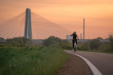 Cyclist riding a bike on the bike path at sunset.の写真素材