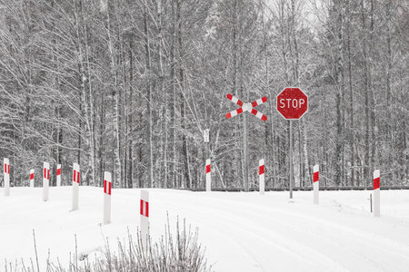 Traffic signs on a country road in winter. The road is covered with snow.の写真素材