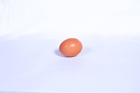 One chicken egg isolated on a white background. theme food, ingredients, healthy, vegetables, vegetarian, rawの写真素材