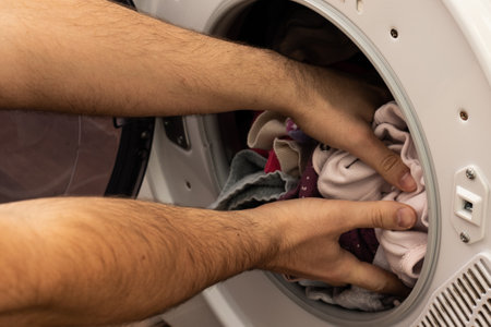 Man washing child's clothes with a washing machine